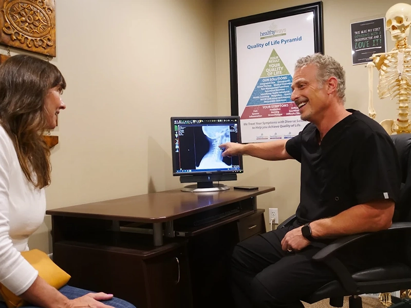 Dr.Joseph Pettinato DC showing neck X-Ray to a patient